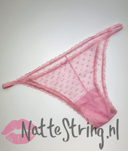 Doorschijnend roze slipje met stipjes gedragen